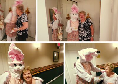 A person dressed as a whimsical bunny interacts with two women indoors.